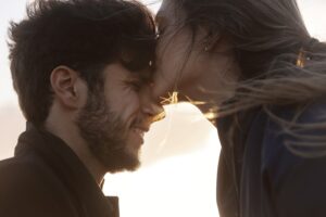 woman kissing man forehead