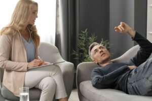 man laying couch therapy cabinet near counselor