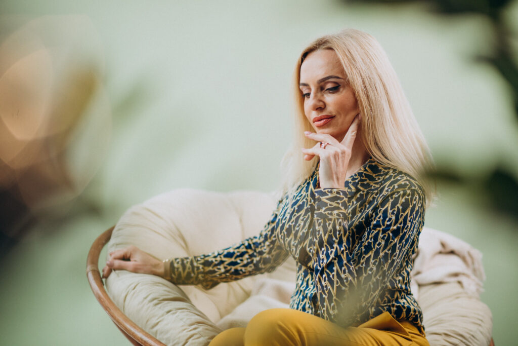 Dospelá štýlová žena sediaca na stoličke